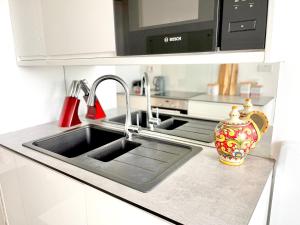 encimera de cocina con fregadero y microondas en Paddington Flat Close to Station with Patio en Londres