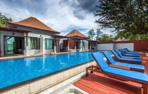 rząd niebieskich leżaków przy basenie w obiekcie Lanta Sand Resort & Spa w mieście Ko Lanta