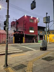 a red building on the corner of a street at Hotel novo sol santo amaro in Sao Paulo