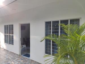 a palm tree in front of a white building at Cabañas Chavita PISO 1 Coveñas in Coveñas
