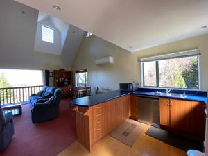 a kitchen with a counter top and a living room at 16 Oregon Heights in Hanmer Springs +23 photos