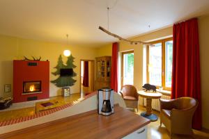 Plumbohms ECHT-HARZ-HOTEL في باد هاغزبورغ: غرفة معيشة مع موقد وستائر حمراء