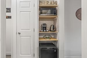 a kitchen with a pantry with a microwave and a door at NEW! Central Canmore- Light Industrial Hotel Room in Canmore