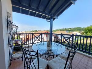 a balcony with a glass table and chairs at Maison avec jardin, terrasse et parking proche plage - FR-1-239-772 in Urrugne