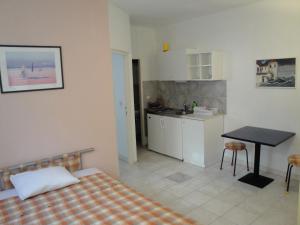 a bedroom with a bed and a table and a kitchen at Apartment Kordić in Sveta Nedelja +35 photos