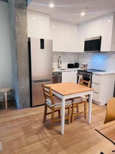 a kitchen with a table and chairs and a refrigerator at The Will I Am in Montreal