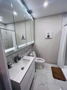 uma casa de banho branca com um WC e um lavatório em The Will I Am em Montreal
