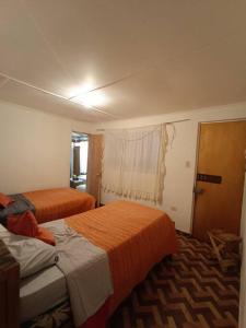 a hotel room with two beds and a window at Alojamiento Abigal in Pica