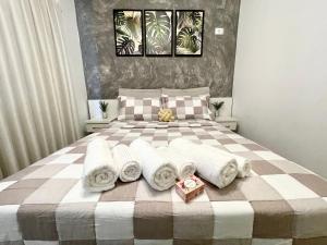 1 dormitorio con 1 cama con toallas en Apê 104-B Confortável no Centro, en Foz do Iguaçu