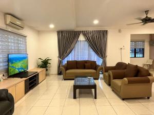 a living room with two couches and a flat screen tv at Pleasant Stay @ Sunway (16-20 pax ) 5 min to Lost World of Tambun in Tambun