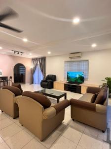 a living room with couches and a flat screen tv at Pleasant Stay @ Sunway (16-20 pax ) 5 min to Lost World of Tambun in Tambun