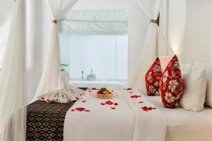 a bedroom with a bed with red and white pillows at Alam Bidadari Seminyak in Seminyak