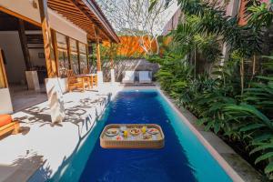 een zwembad met een dienblad met eten in een huis bij Alam Bidadari Seminyak in Seminyak