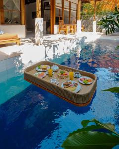 una bandeja de comida en una mesa de la piscina en Alam Bidadari Seminyak, en Seminyak