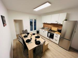 Il comprend une cuisine équipée d'une table et d'un réfrigérateur. dans l'établissement City Apartment - 9 Bedrooms - 22 Beds - WiFi - Kitchen, à Paderborn