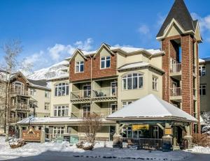 a large apartment building with snow on the ground at NEW! Central Canmore- Light Industrial Hotel Room in Canmore