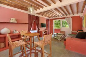 uma sala de estar com uma mesa e cadeiras e um sofá em PinkCoco Gili Trawangan - Constant Surprises - for Cool Adults Only em Gili Trawangan