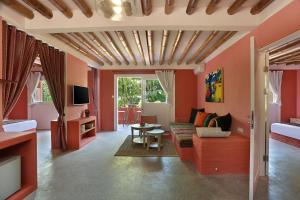 een woonkamer met rode muren en een bank en een tafel bij PinkCoco Gili Trawangan - Constant Surprises - for Cool Adults Only in Gili Trawangan