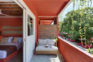 a small balcony with a bed and a window at PinkCoco Gili Trawangan - Constant Surprises - for Cool Adults Only in Gili Trawangan