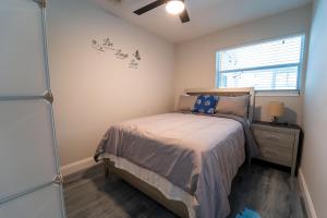 ein kleines Schlafzimmer mit einem Bett und einem Fenster in der Unterkunft Bacolet Beach Luxe Pool Cottage in Palm Beach Gardens + 31 Fotos