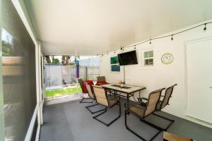 eine Terrasse mit einem Tisch und Stühlen sowie einem TV in der Unterkunft Bacolet Beach Luxe Pool Cottage in Palm Beach Gardens