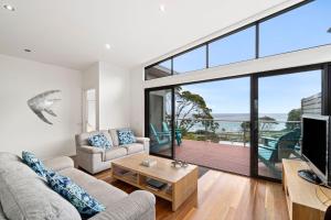 a living room with a large window and a tv at Earth Sea Sky in Wye River