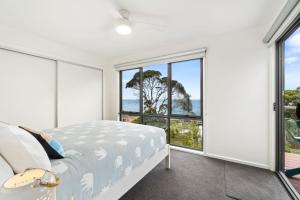 a bedroom with a bed and a view of the ocean at Earth Sea Sky in Wye River