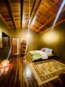 um quarto com uma cama e um tecto de madeira em Kalis Inn em Alto Paraíso de Goiás