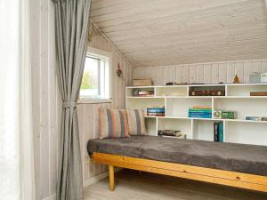 Zimmer mit einem Bett, einem Fenster und Regalen in der Unterkunft Holiday home Ølsted IV in Ølsted