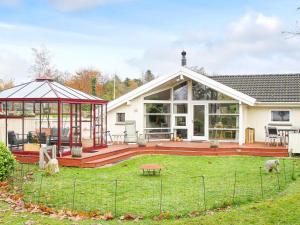 une maison avec une terrasse et un kiosque dans l'établissement Holiday home Ølsted IV, à Ølsted