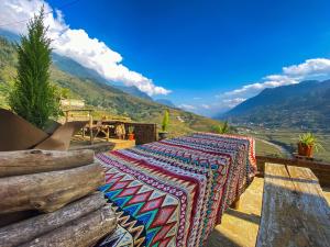 una mesa con una alfombra colorida en la cima de una montaña en Vietoutdoors Homestay, en Sa Pa