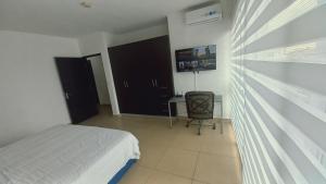 - une chambre avec un lit, un bureau et une fenêtre dans l'établissement Blue Dream, à Panama City