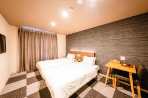 a hotel room with two beds and a table at HOTEL THE POINT Kiyomizu Gojo in Kyoto