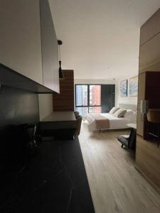 - une grande chambre avec un lit et une grande fenêtre dans l'établissement Hermoso y cómodo ApartmentStudio, à Quito