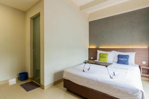 a bedroom with a bed with a laptop on it at Urbanview Hotel Slipi Inn Palmerah in Jakarta
