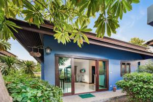 a blue house with glass doors and trees at MyVillage Lamai in Lamai