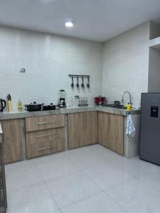 a large kitchen with wooden cabinets and a refrigerator at Dpto. Estreno - Centro Histórico - 110 M2 in Trujillo