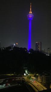 a tower is lit up in blue at night at Studio Bedroom with Balcony in Kuala Lumpur