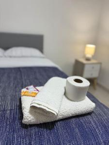una toalla y un rollo de papel higiénico en una cama en Dpto. Estreno - Centro Histórico - 110 M2, en Trujillo