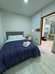 Schlafzimmer mit einem Bett mit blauer Decke in der Unterkunft Dpto. Estreno - Centro Histórico - 110 M2 in Trujillo
