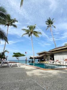a resort with a swimming pool and palm trees at Sea Shell Beach Resort in Ko Lanta
