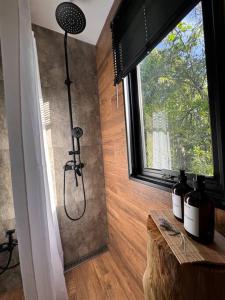 a shower in the corner of a room with a window at Nandina, en el bosque y playa in La Pedrera