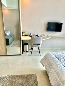 - une chambre avec un bureau, une chaise et un lit dans l'établissement GREEN SEDAYU APARTMENT b28, à Jakarta