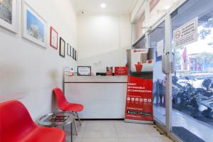 ein Restaurant mit einem roten Stuhl und einer Theke in der Unterkunft RedDoorz @ Garden Boulevard Citra Raya Tangerang in Tangerang