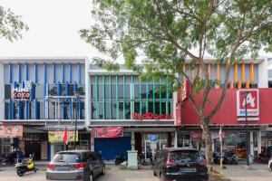 eine Straße mit Autos, die vor einem Gebäude geparkt sind in der Unterkunft RedDoorz @ Garden Boulevard Citra Raya Tangerang in Tangerang