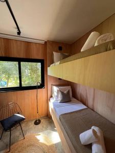 a small room with a bed and a shelf at Nandina, en el bosque y playa in La Pedrera
