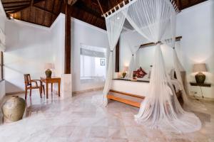 a room with a bed with mosquito nets in it at Alam Bidadari Seminyak in Seminyak +20 photos