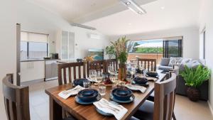comedor con mesa y sillas y cocina en Fern's Retreat, en Kiama