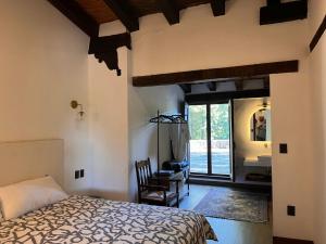 Villa del Lago في باتزكوارو: غرفة نوم بسرير ومكتب ونافذة