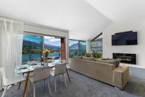 a living room with a couch and a table with chairs at Remarkable Hideaway by Relaxaway Holiday Homes in Queenstown